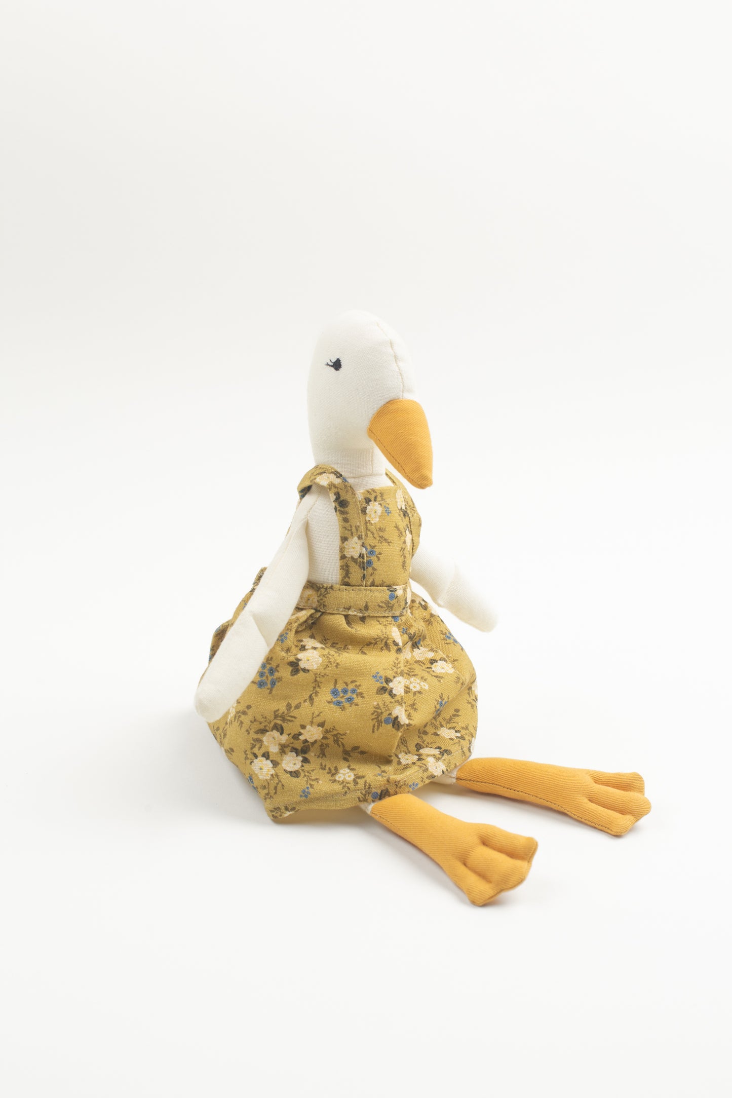 Meet Birdie, the softie duck doll by Bonnie Christine, dressed in a breezy floral linen dress and handcrafted from soft cotton, perfect for children’s playtime, snuggles, or adding a whimsical charm to any child’s space or nursery shelf decor.