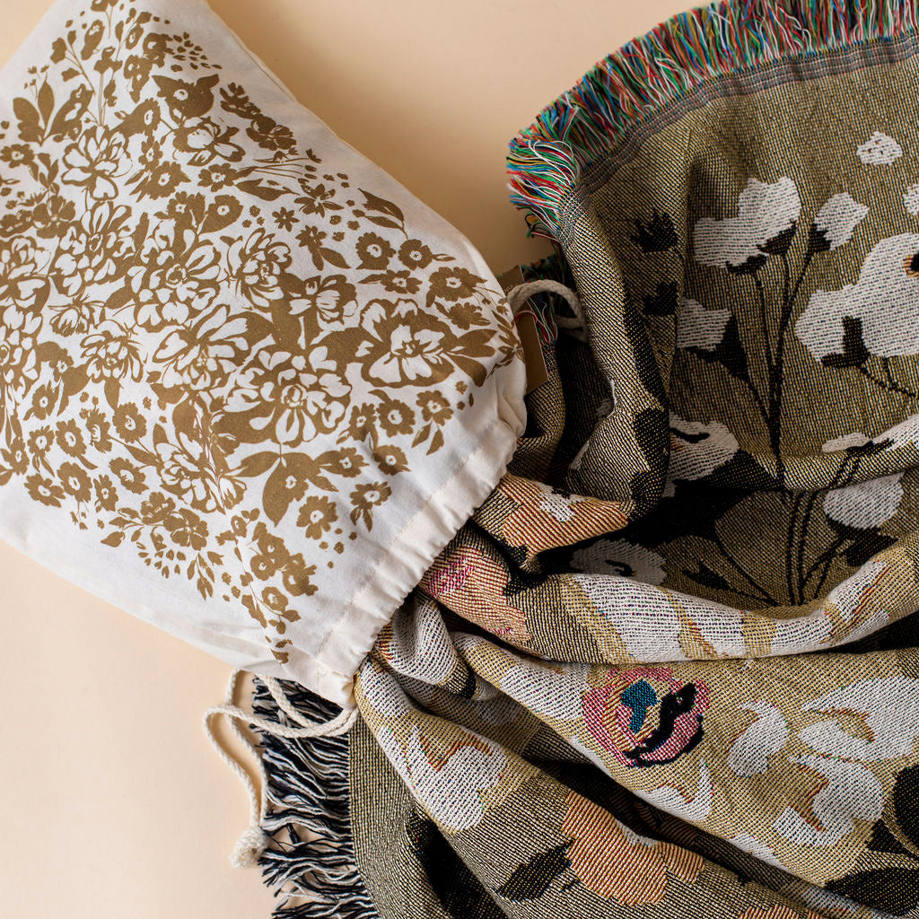 This Cocoon Throw Blanket by Bonnie Christine, woven from 100% Carolina-grown cotton in a floral jacquard tapestry, brings a touch of cottage-core charm to cozy home moments, perfect for gifting, layering, or a garden picnic.