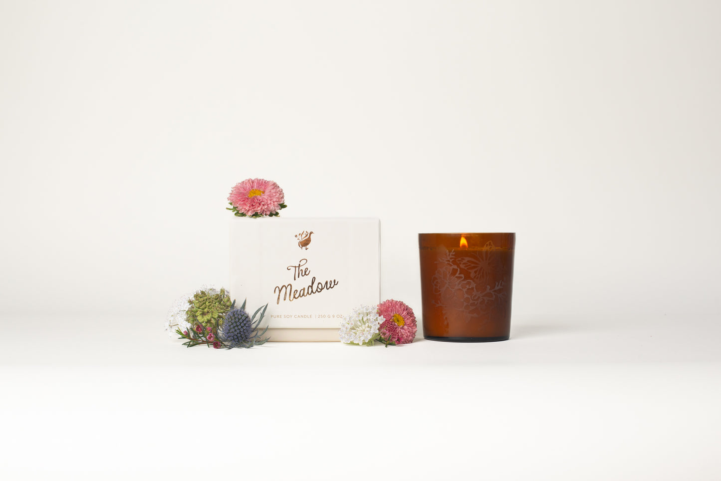 This Meadow Signature Candle by Bonnie Christine, with its etched floral amber glass vessel and handmade box, adds a warm, inviting touch to home decor, making it the perfect gift or housewarming present for those who love cozy, artful spaces.