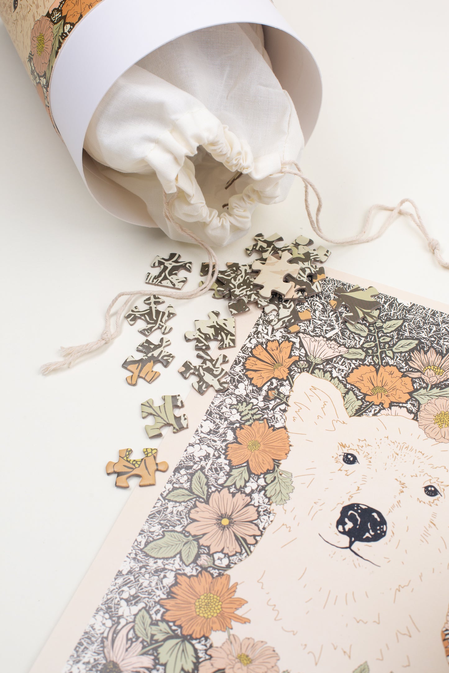 This Woodland Dreams Puzzle by Bonnie Christine features a friendly bear and wildflowers in a charming design, with 1000 pieces packaged in a rigid tube box, perfect for gifting or enjoying quiet cottage-core afternoons.