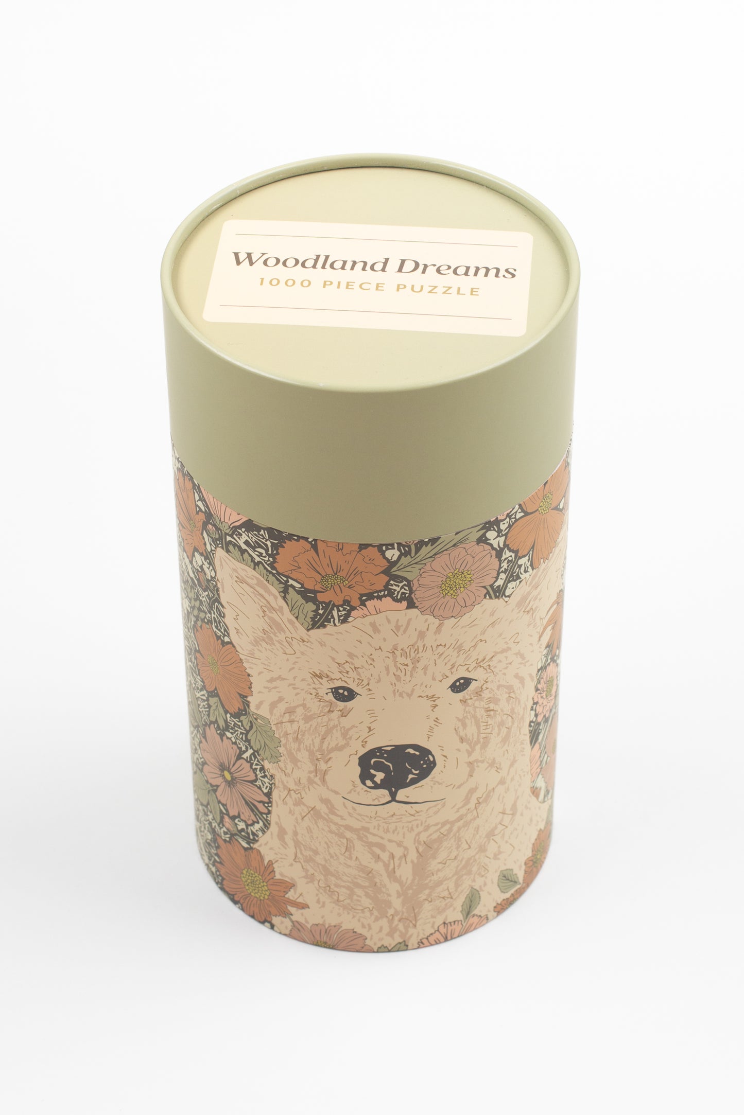 This Woodland Dreams Puzzle by Bonnie Christine features a friendly bear and wildflowers in a charming design, with 1000 pieces packaged in a rigid tube box, perfect for gifting or enjoying quiet cottage-core afternoons.
