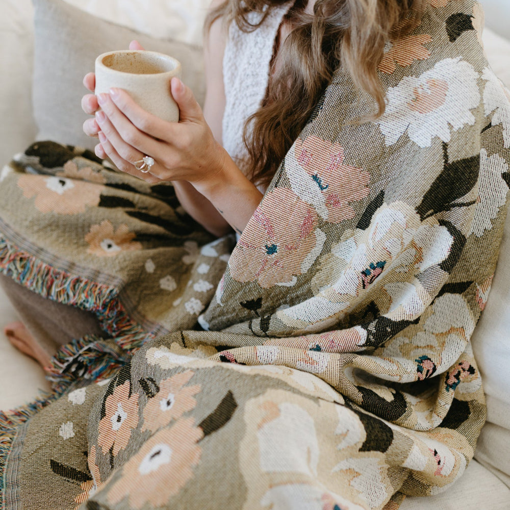 
                  
                    This Cocoon Throw Blanket by Bonnie Christine, woven from 100% Carolina-grown cotton in a floral jacquard tapestry, brings a touch of cottage-core charm to cozy home moments, perfect for gifting, layering, or a garden picnic.
                  
                