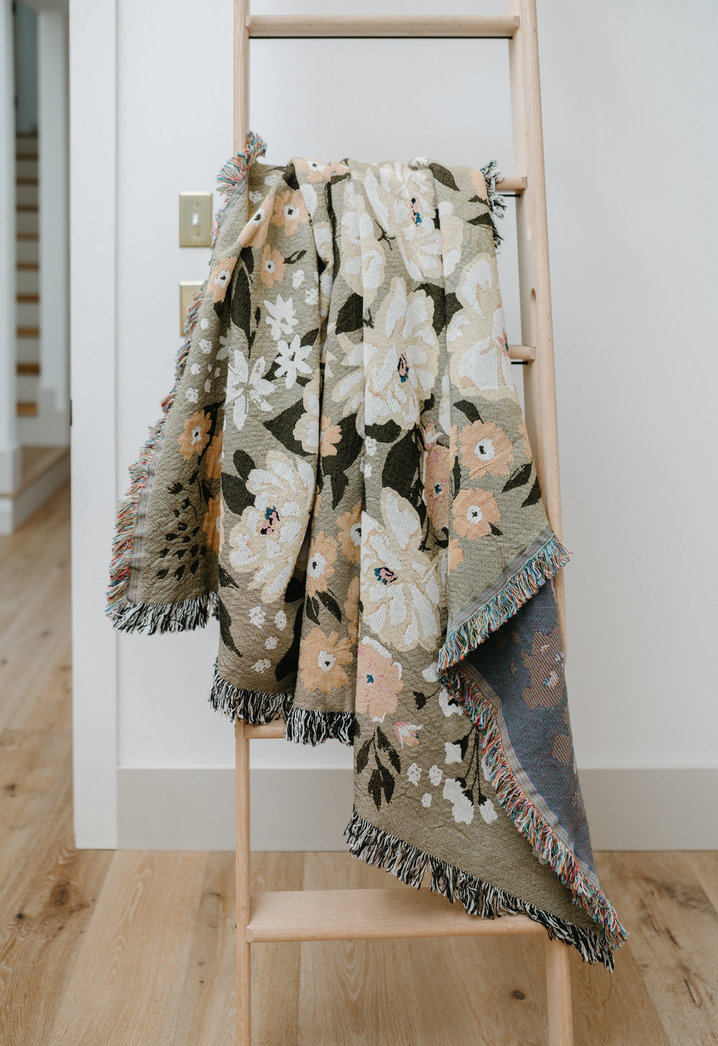 This Cocoon Throw Blanket by Bonnie Christine, woven from 100% Carolina-grown cotton in a floral jacquard tapestry, brings a touch of cottage-core charm to cozy home moments, perfect for gifting, layering, or a garden picnic.