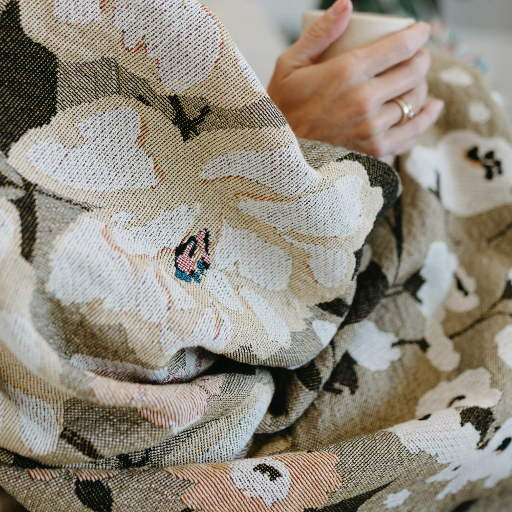 
                  
                    This Cocoon Throw Blanket by Bonnie Christine, woven from 100% Carolina-grown cotton in a floral jacquard tapestry, brings a touch of cottage-core charm to cozy home moments, perfect for gifting, layering, or a garden picnic.
                  
                